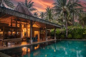 a swimming pool in front of a villa at Beach Villas Lombok in Tanjung