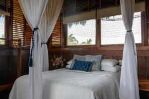 Cama en habitación con ventana en Casa Kundavi Beach Front Paradise en Recado