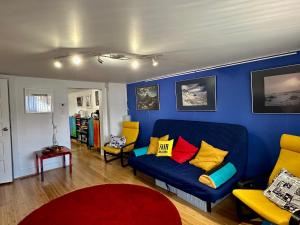 uma sala de estar com um sofá azul e cadeiras amarelas em Unique Artsy 2 Bdrm Apt 1.5 mi from Downtown em Pittsburgh