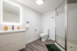 uma casa de banho branca com um WC e uma cabina de duche em vidro. em Cozy Fully-Equipped 2 Bedroom Suite em Halifax