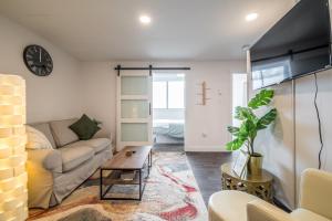 Cozy Fully-Equipped 2 Bedroom Suite في هاليفاكس: غرفة معيشة مع أريكة وطاولة