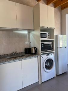 a kitchen with a washing machine and a microwave at Lautaro in San Juan