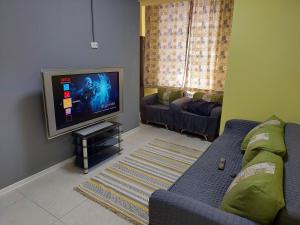 a living room with a couch and a flat screen tv at Check Inn Hostel in Almaty