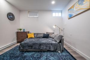 ein Schlafzimmer mit einem Bett und einer Uhr an der Wand in der Unterkunft Spacious Newly Renovated 1 Bedroom Suite in Halifax