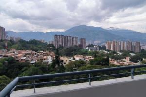 - une vue sur une ville avec des bâtiments et des montagnes dans l'établissement Apartamento Bello amazonia - Medellín, à Bello