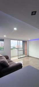 - un salon avec un canapé et une grande fenêtre dans l'établissement Apartamento Bello amazonia - Medellín, à Bello