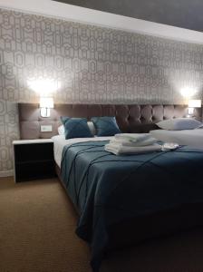 a hotel room with two beds and two lamps at De Marco Hotel in Kostanay