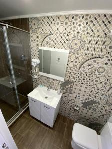 a bathroom with a sink and a shower and a toilet at De Marco Hotel in Kostanay