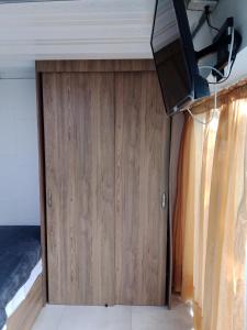 a bedroom with a wooden door with a television on it at Bird House - Apartament in Jardin