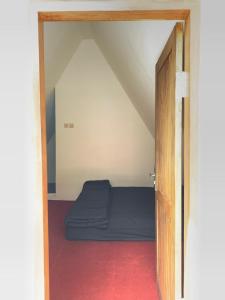 Una puerta a una habitación con cama en un ático en Jambusari Ijen Crater Cottage, en Jambu