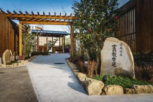a rock in a garden next to a walkway at HOTEL MYSTAYS Matsuyama in Matsuyama