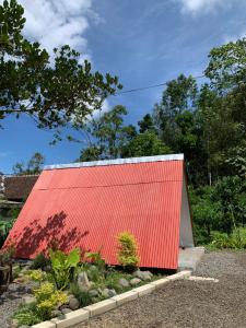 una casa roja con techo rojo en Jambusari Ijen Crater Cottage, en Jambu