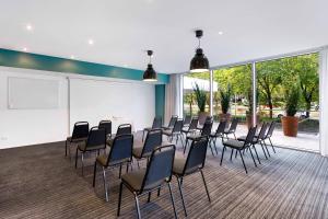 einen Konferenzraum mit Stühlen und einer weißen Wand in der Unterkunft Park Regis Griffin Suites in Melbourne
