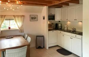 cocina con armarios blancos y mesa de madera en Lovely Home In Ijhorst With Wifi, en IJhorst