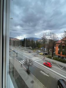a view of a street with a red car on the road at CENTRAL Colors Studio Petrosani in Petroşani