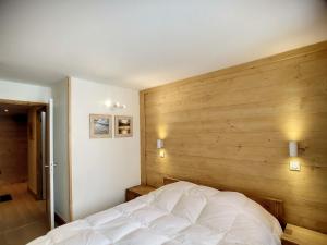 sypialnia z białym łóżkiem i drewnianą ścianą w obiekcie Spacieux 3 pièces cabine, 6 pers, 62m² aux pieds des pistes, Les Bruyères, Les Menuires - FR-1-178-359 w Les Menuires