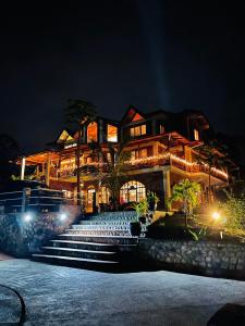 una casa grande con luces encendidas por la noche en La Casa del Rio B&B, en Puyo