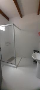 Habitación blanca con puerta de cristal en el suelo en Karina House, en Jardín América