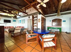 een woonkamer met een blauwe tafel en stoelen bij Casa beiramar com piscina na Ilha de Itacuruca RJ in Mangaratiba