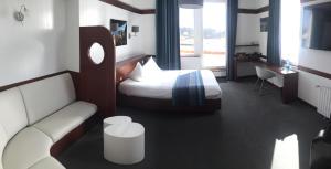 a hotel room with a bed and a couch at Hôtel des Rochers in Perros-Guirec