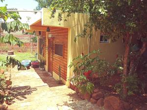 a house with a brick walkway next to a building at Hostel Sin Fronteras in Puerto Iguazú