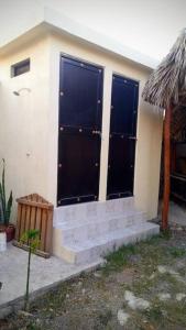 une maison avec des portes noires sur son côté dans l'établissement Casa de campo en Ciudad Valles, à Ciudad Valles