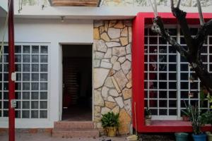 budynek z czerwonymi drzwiami i kamienną ścianą w obiekcie Casa de campo en Ciudad Valles w mieście Ciudad Valles