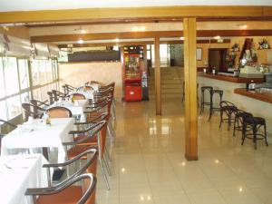a restaurant with white tables and chairs and a bar at Hotel Manzanares in Manzanares