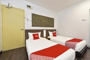 Cette chambre comprend 2 lits avec des draps rouges et blancs. dans l'établissement 4S Hotel, à Muar