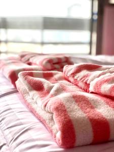 una fila di coperte rosse e bianche su un letto di Mike's Condo a Si Racha