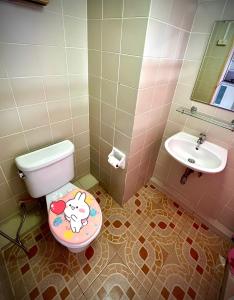 a bathroom with a toilet and a sink at Mike's Condo in Si Racha