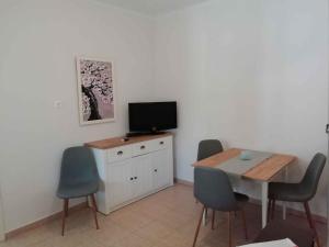 une salle à manger avec une table et une télévision sur un mur blanc dans l'établissement Holiday home in Balatonkeresztur 44078, à Balatonkeresztúr