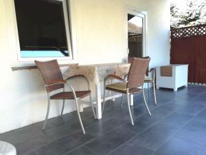une table et des chaises sur une terrasse avec une fenêtre dans l'établissement Holiday home in Balatonkeresztur 44078, à Balatonkeresztúr 5 autres photos