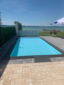 une grande piscine bleue avec vue sur l'eau dans l'établissement Apartment in Balatonlelle 44077, à Balatonlelle