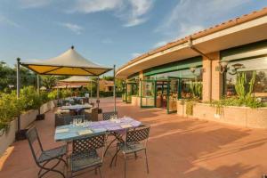 eine Terrasse mit einem Tisch und Stühlen sowie ein Gebäude in der Unterkunft Apartment in Follonica - Toskana 44106 in Follonica