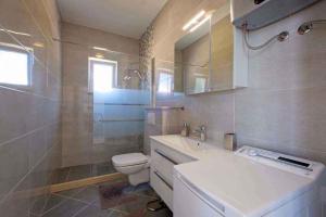 uma casa de banho com um lavatório branco e um WC. em Apartments in Mlini 44021 em Mlini