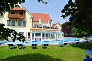 a house with a pool and chairs in the yard at Apartment in Bad Waltersdorf - Steiermark 44009 in Bad Waltersdorf