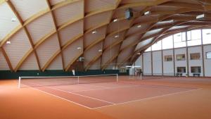 a tennis court in a building with a wooden ceiling at Apartment in Bad Waltersdorf - Steiermark 44009 in Bad Waltersdorf