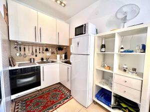 Una cocina con gabinetes blancos y un refrigerador. en Apartment in Jadranovo 44072, en Jadranovo 20 fotos más