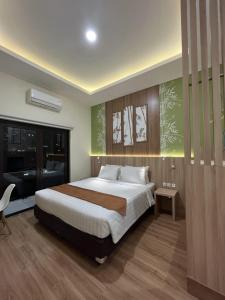 1 dormitorio con 1 cama grande y TV en D'Bamboo Suites, en Yakarta