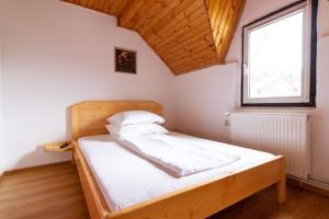 a bed in a small room with a window at Casa Cornel in Vartop