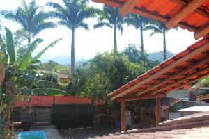 a view of a house with palm trees in the background at Hospedagem Caminho das Águas in Paraty