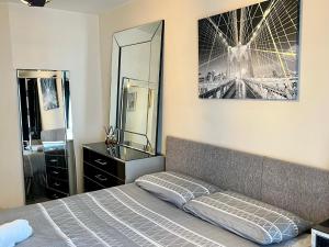 a bedroom with a bed and a dresser and a mirror at Radiant2 bedroom apartment in the heart of Harlow town in Harlow