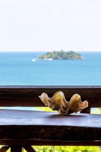 a wooden bench with a view of the ocean at Sweet View Guesthouse in Koh Rong