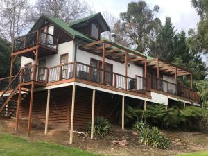a house with a wrap around porch and decks at Day Dream Cottage in Merrijig