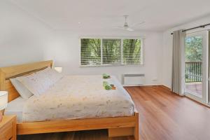 a bedroom with a bed and a large window at Jarrah Lodge in Merrijig