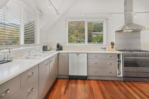 a kitchen with white cabinets and a stove top oven at Jarrah Lodge in Merrijig