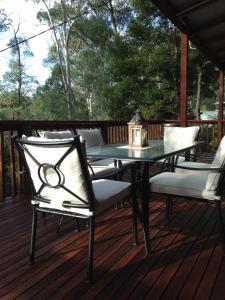 una mesa de patio y sillas en una terraza en Kookas Cottage en Merrijig