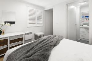 a white bedroom with a bed and a sink at Elkhorn 17 - Mt Buller Village in Mount Buller