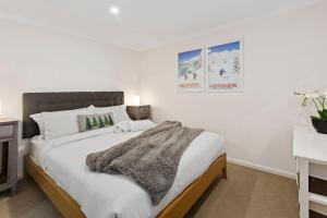 a bedroom with a large bed with a blanket on it at Elkhorn 17 - Mt Buller Village in Mount Buller